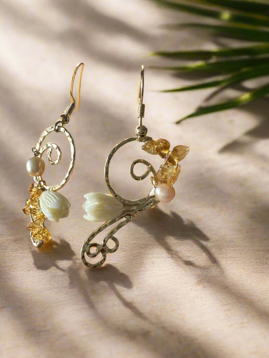 Pair of floral earrings on a textured stone surface
